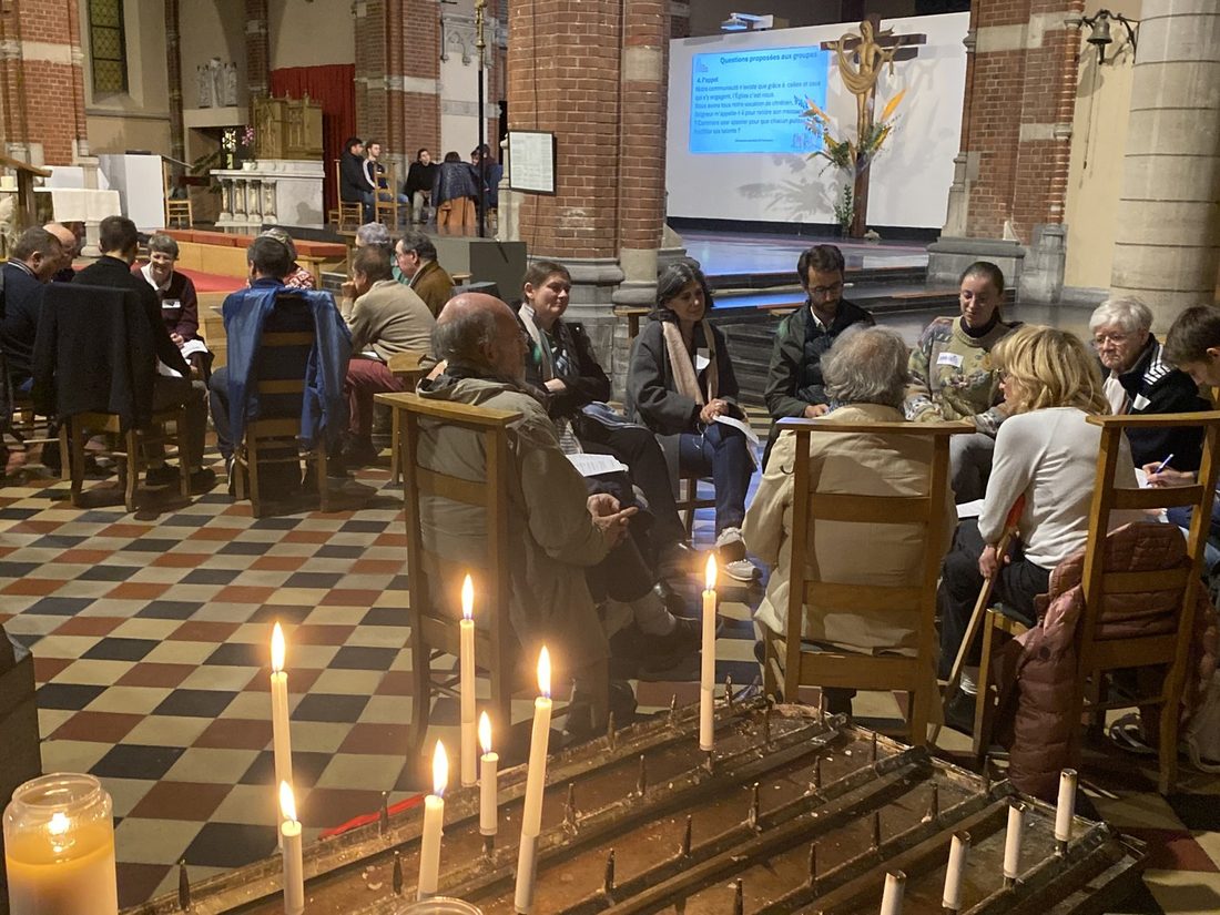 Kringgesprek in een kerk, met kaarsen op de voorgrond